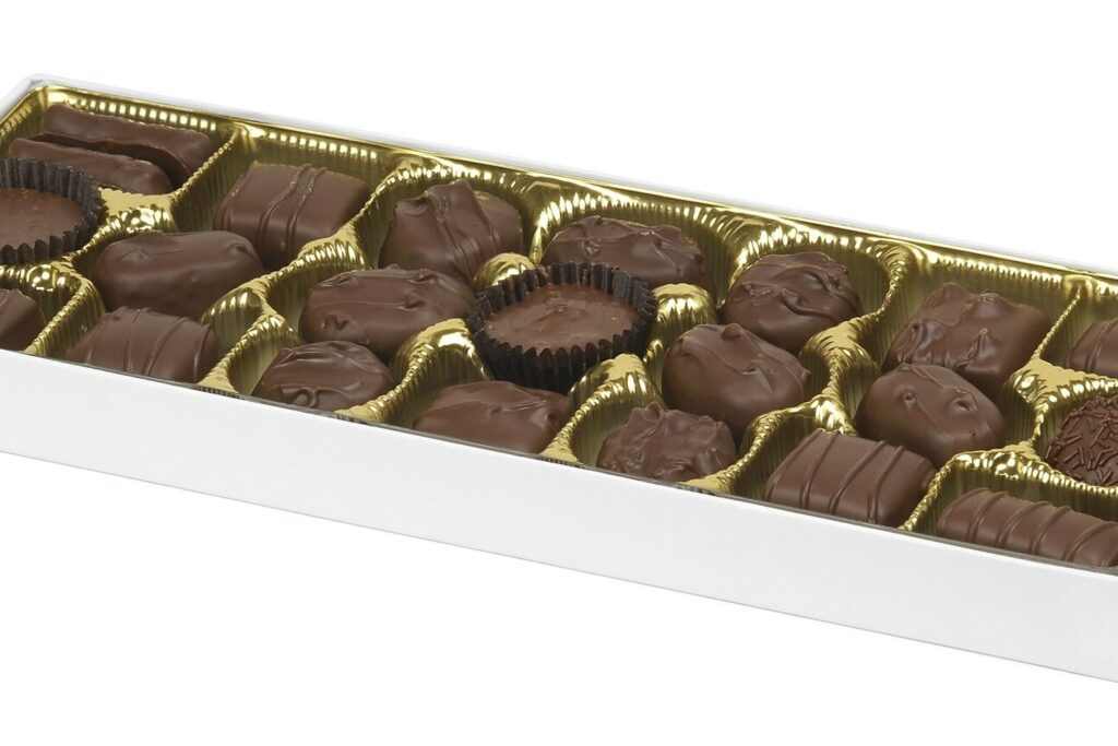 Weiße Schachtel mit gefüllten Schokoladenpralinen