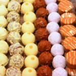 Reihen bunter Pralinen und Trüffel in einer Confiserie-Auslage