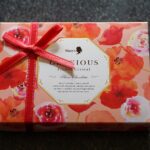 Mit roter Schleife verpackte Geschenkschachtel mit Schokolade