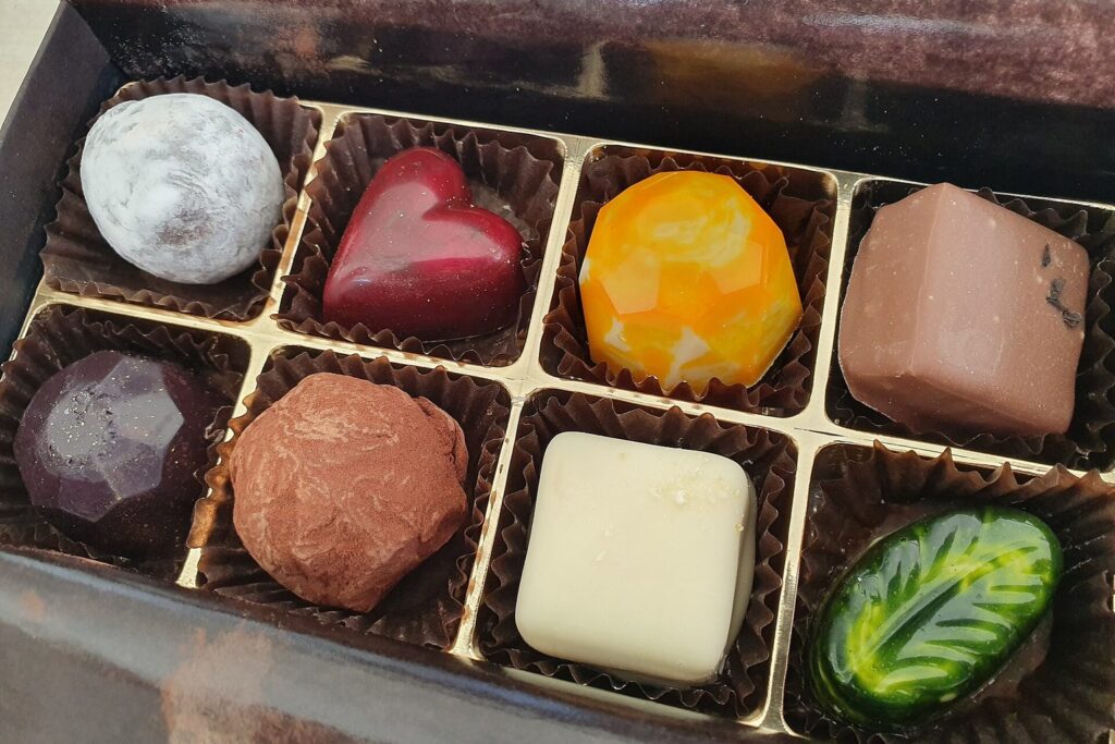 Geöffnete Schachtel mit bunten, handgefertigten Pralinen