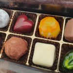 Geöffnete Schachtel mit bunten, handgefertigten Pralinen