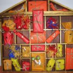 Selbst gebastelter Adventskalender aus Holz mit kleinen verpackten Geschenken