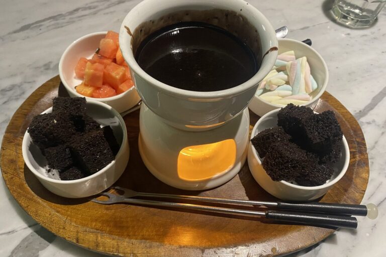 Schokoladenfondue mit Früchten, Brownies und Marshmallows in Schälchen